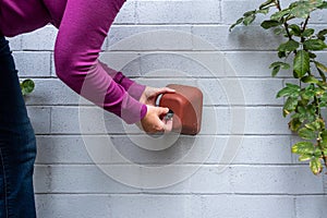 Winterization, womanÃ¢â¬â¢s hands installing foam and plastic faucet cover to prevent pipes freezing photo